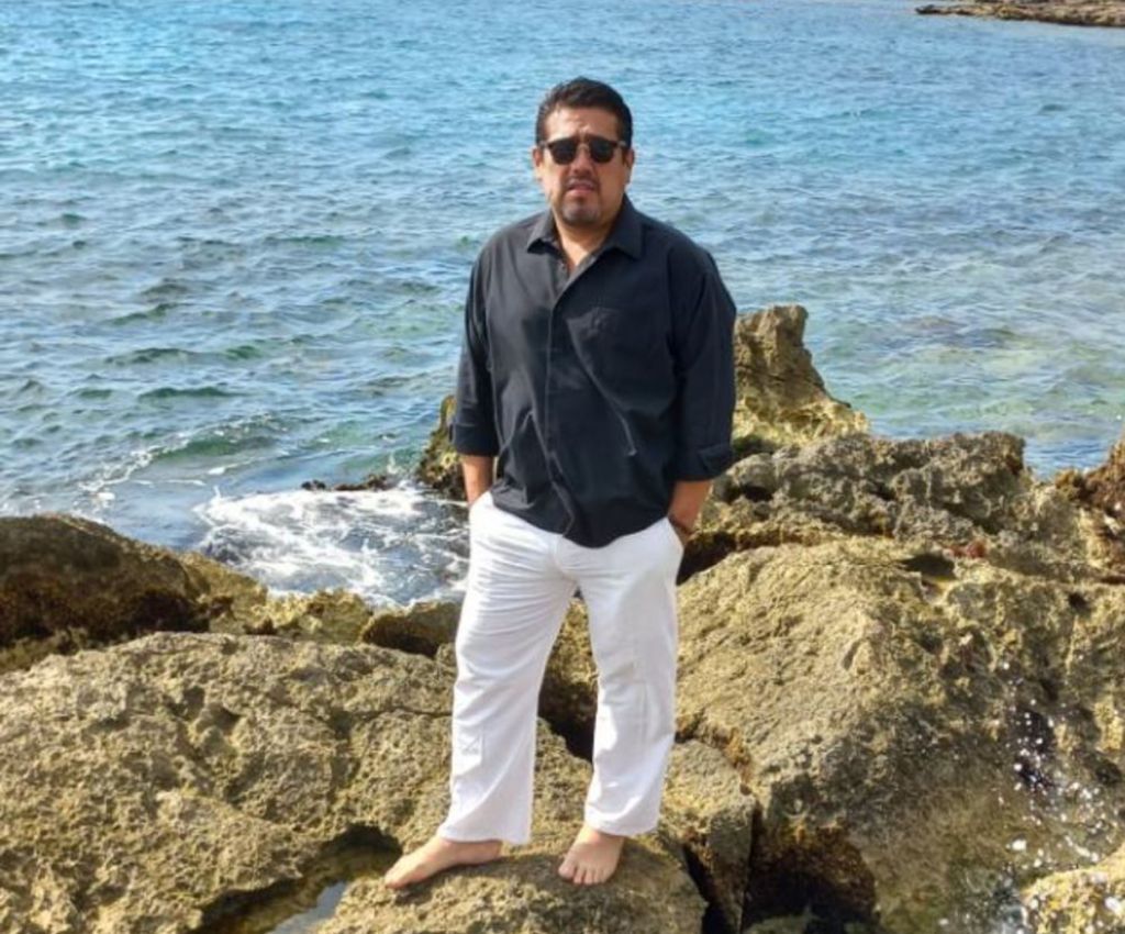 Presunto estafador Alberto Jiménez Cáceres vestido de pantalón blanco y camisa azul.